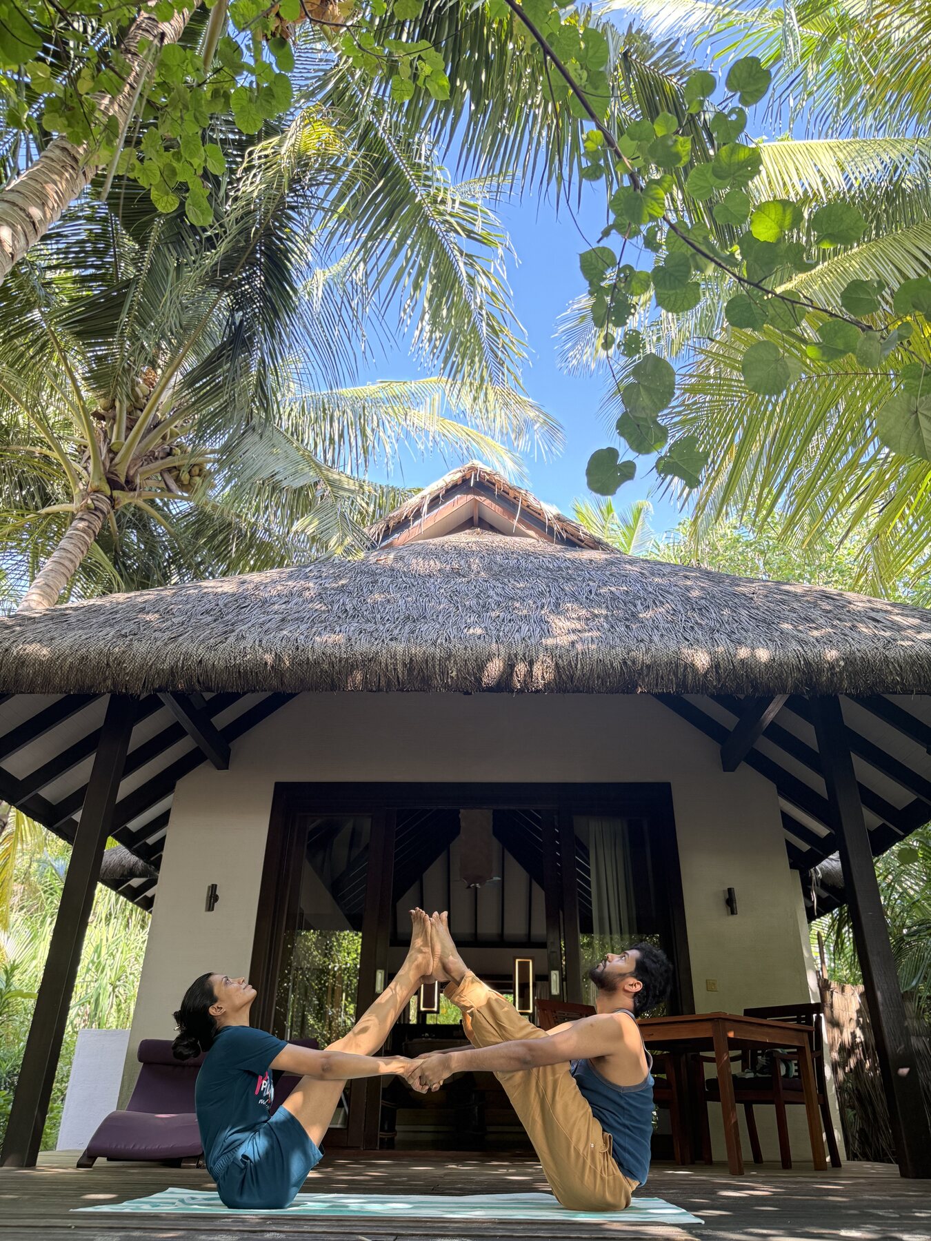 Monika Laheri and Surya Bhanu practising partner yoga outdoors